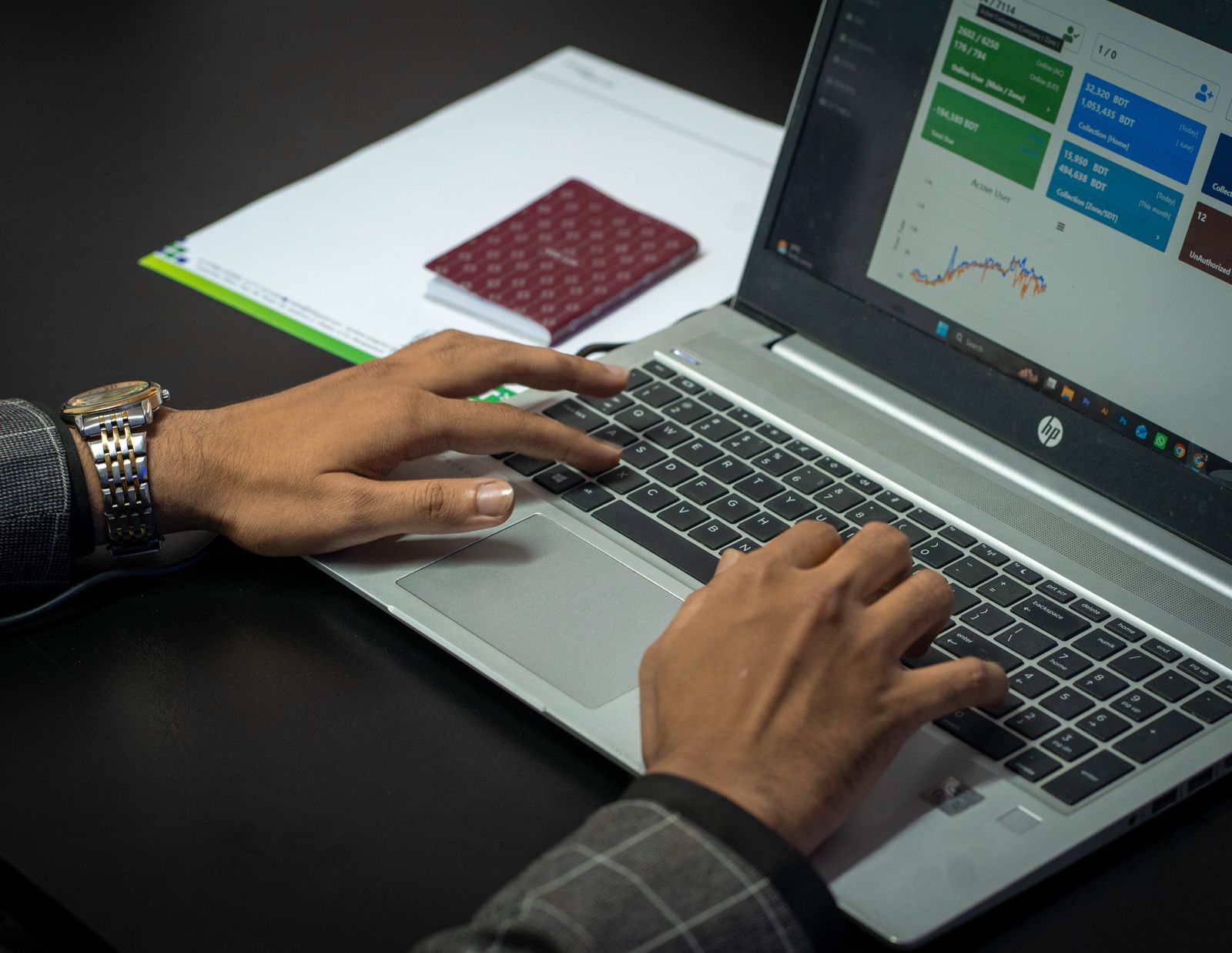 Mãos sobre teclado de notebook analisando painel de indicadores